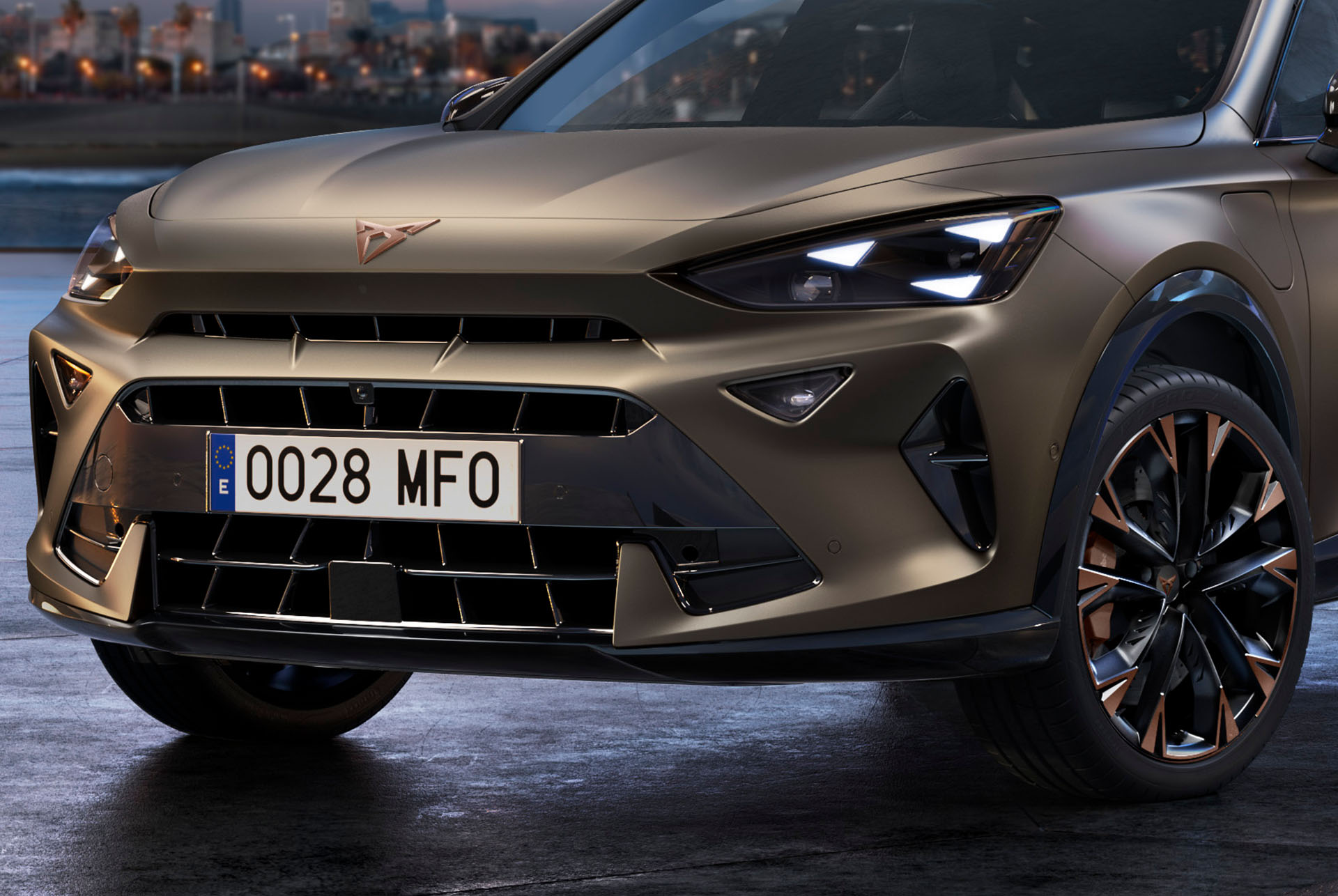 Close up of the front of a new century bronze 2024 CUPRA Formentor CUV with copper accent wheels, signature triangle eye front lights and distinctive CUPRA logo.