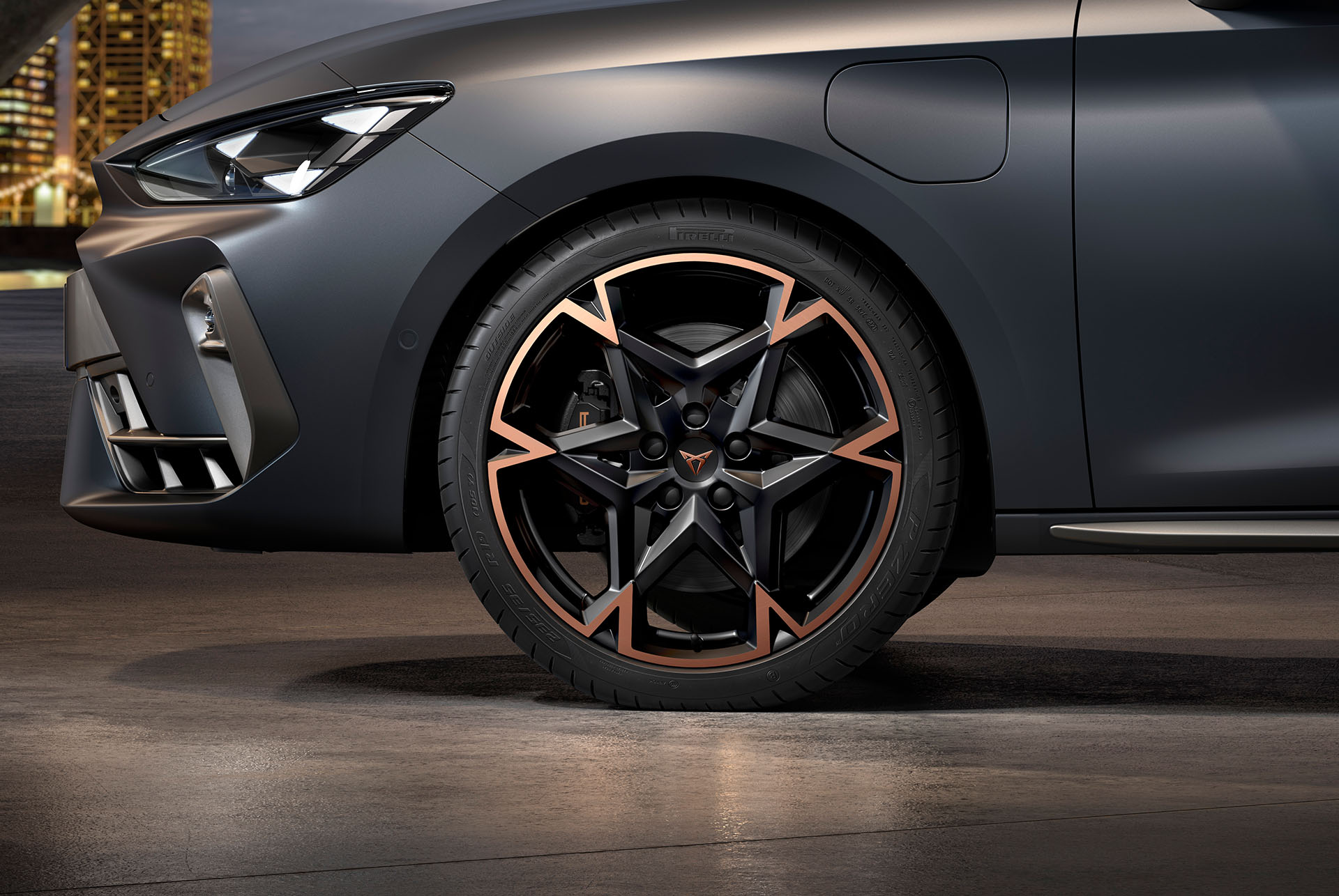 front side view of left machined alloy wheel in black and copper for the new cupra leon spotstourer 2024, tyres, signature headlights and grey body